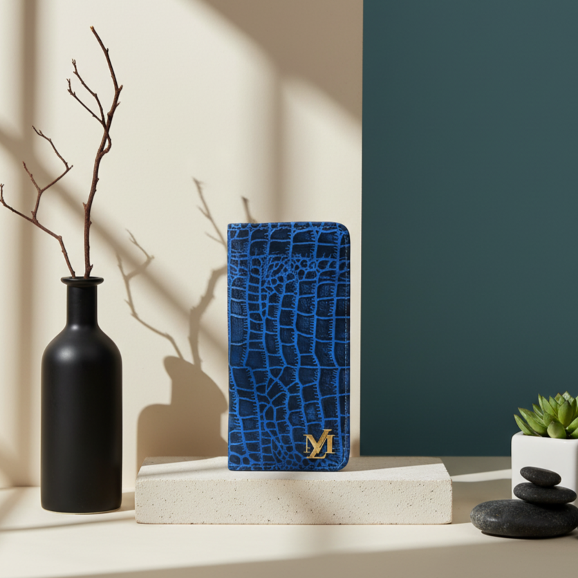 Blue crocodile-textured Leather wallet case with a brand logo on a white surface with decorative items.