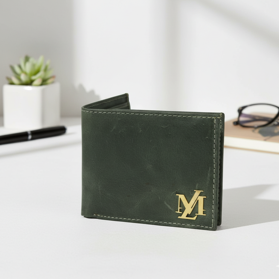 Green leather wallet with gold logo on a white surface with a plant and glasses in the background